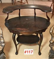 Full front view of mahogany parlour table showing gallery top, apron carving, cabriole legs and lower shelf.