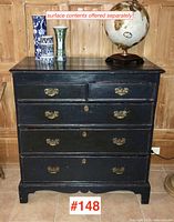 Full front view of chest showing overall shape, painted black finish, five drawers and brass handles.