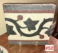 Front view displaying the floral vine decorative design on the square tile.