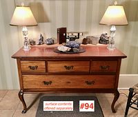 Front elevation of sideboard showing three small drawers above one full-width drawer, brass bail pulls, cabriole legs.