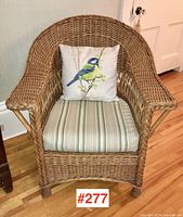 Front view of wicker armchair with striped cushion and bird pillow