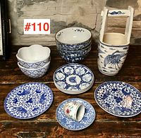Overview of entire lot showing stacked bowls, plates, cup and handled vessel