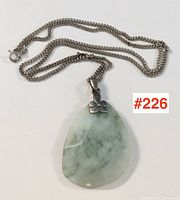 Full view of sterling chain with jade pendant laid flat
