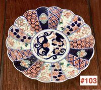 Top view of the Japanese Imari charger plate showing full scalloped edge and detailed multicolored designs including floral and geometric patterns.