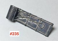 Close-up front view of the toboggan brooch showing wire details and embossed design