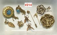 Overview of Victorian and vintage jewellery lot laid out, showing all items including the large circular brooch with turquoise beads, matching earrings, rose brooch, bee earrings, pin, and knot brooch.