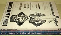 White cover paperback book with caricature illustration of John A. MacDonald and descriptive words.