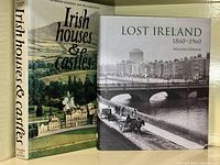 Two hardcover coffee table books with dust jackets: 'Irish Houses & Castles' showing a scenic castle exterior on the cover, and 'Lost Ireland 1860-1960' with a black and white historic Dublin bridge scene cover photo.