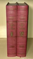 Front view of two red leather-bound book spines with gold embossing, showing volume numbers and date ranges for 'The Ancient Art of Warfare'.