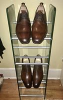 Shoe rack holding two pairs of Edward Green brown leather dress shoes