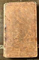 Front cover of the antique book showing worn brown leather, heavy wear and fraying.