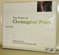 Front cover of the art book 'The Prints of Christopher Pratt 1958-1991' showing title, author credits, and a signed copy sticker.
