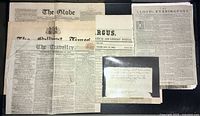 Multiple antique newspapers including The Globe, The Melbourne Times, Argus, Lloyd's Evening Post and The Traveller arranged on a flat surface.