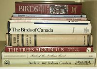 Stacked assortment of nine bird and nature-related books showing variety in size, condition, and titles.