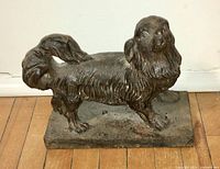 Side view of antique cast iron dog door stop with textured fur and detailed face.