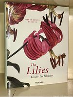 Front cover of The Lilies art book depicting botanical illustrations of red lilies by Pierre-Joseph Redouté