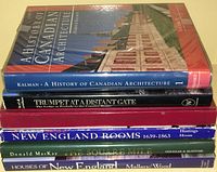 Photo showing a stack of six coffee table books featuring titles related to Canadian and New England architecture and history, all with hard and soft covers.