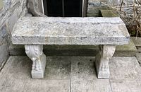 Overall view of limestone bench showing rectangular slab top and two carved supports