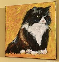 Front view of canvas painting depicting a tuxedo cat on yellow background