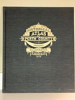 Front cover of the hardbound book showing gold embossed text and decorations on black cloth.