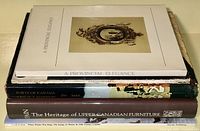 Stack of five reference books on antiques, Canadian art, and furniture with visible titles.