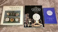 Three hardcover reference books on clocks and watches arranged side-by-side showing covers.