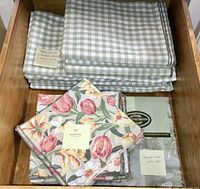 Drawer view with gingham tablecloths stacked and floral napkins on top