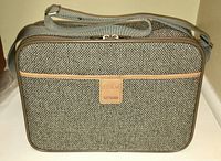 Front view of the travel bag showing woven exterior and brand patch