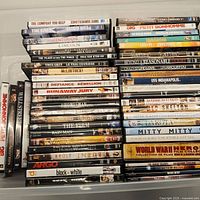 Photo showing the stacked DVDs with readable titles including 'The Firm', 'Runaway Jury', 'Argo', 'Black or White', 'The Horse Whisperer', 'Rain Man', and more.