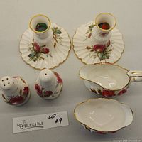 Top view of two Hammersley candlesticks, salt and pepper shakers, and cream and sugar dishes with rose and gold floral designs.