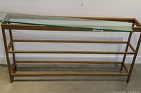 Full front view of bronze-finish metal hall table showing overall structure