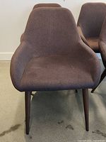 Four chestnut brown Style In Form Tina chairs in fabric upholstery showing front and partial side views, placed indoors on carpeted floor.