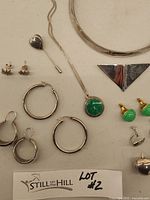Full lot layout showing necklaces, various earrings, triangular pendant, bangles, and jewelry box label.
