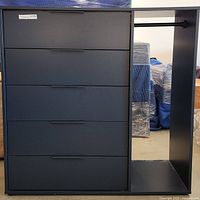 Front view of wardrobe cabinet showing five drawers on left and open hanging space on right.