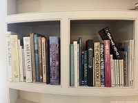 Spine view of art and architecture-themed books including titles on Degas, Monet, American Art, Chinese paintings, and contemporary art.