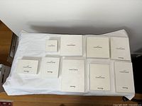 Top view of multiple white boxes with Concorde and British Airways branding on lids, displayed on a white cloth-covered surface.