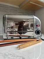 Front angle view of chrome metal toaster showing four slots and branding