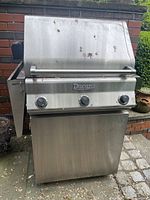 Full front view of Ducane stainless steel gas grill with lid closed, shows rust spots and metal finish.
