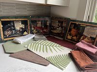 Image showing variety of placemats arranged on a countertop with folded napkins.