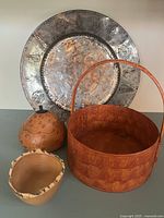 Photo showing all items in the set: large metal plate, round wooden basket with handle, carved wooden bowl, and small carved wooden item.