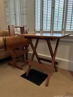 Natural wood folding TV tray set with one tray open and one tray folded on wooden stand