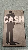 Front cover of the digipak showing Johnny Cash standing and the text 'CASH THE LEGEND'.