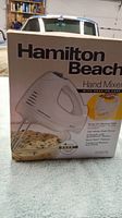 Photo of the boxed Hamilton Beach Hand Mixer with product details visible on the packaging.