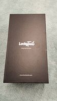 Closed black box with LuckyTail logo and dog nail grinder text on top, indicating original packaging.