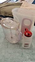 Photo of all items in the Rubbermaid clear and red plastic container set showing the pitcher, two rectangular containers, and creamer canister.