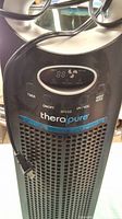 Front close-up view of the black Therapure air purifier digital control panel showing timer, on/off, speed, UV/VOC and night mode buttons, with a power cord attached.