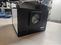 Front angle view of the black Ambico video transfer device showing the circular viewing window and part of the casing.