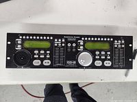 Full front view of the American Audio CDG-350 remote control unit showing dual green LCD screens, multiple buttons, and faders.