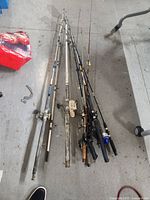 Overview image showing 8 fishing rods laid out on the floor, various reels attached and rod types visible.