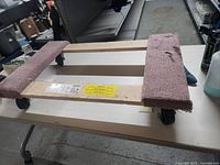 Photo of wooden furniture dolly showing top carpet-covered pads and frame